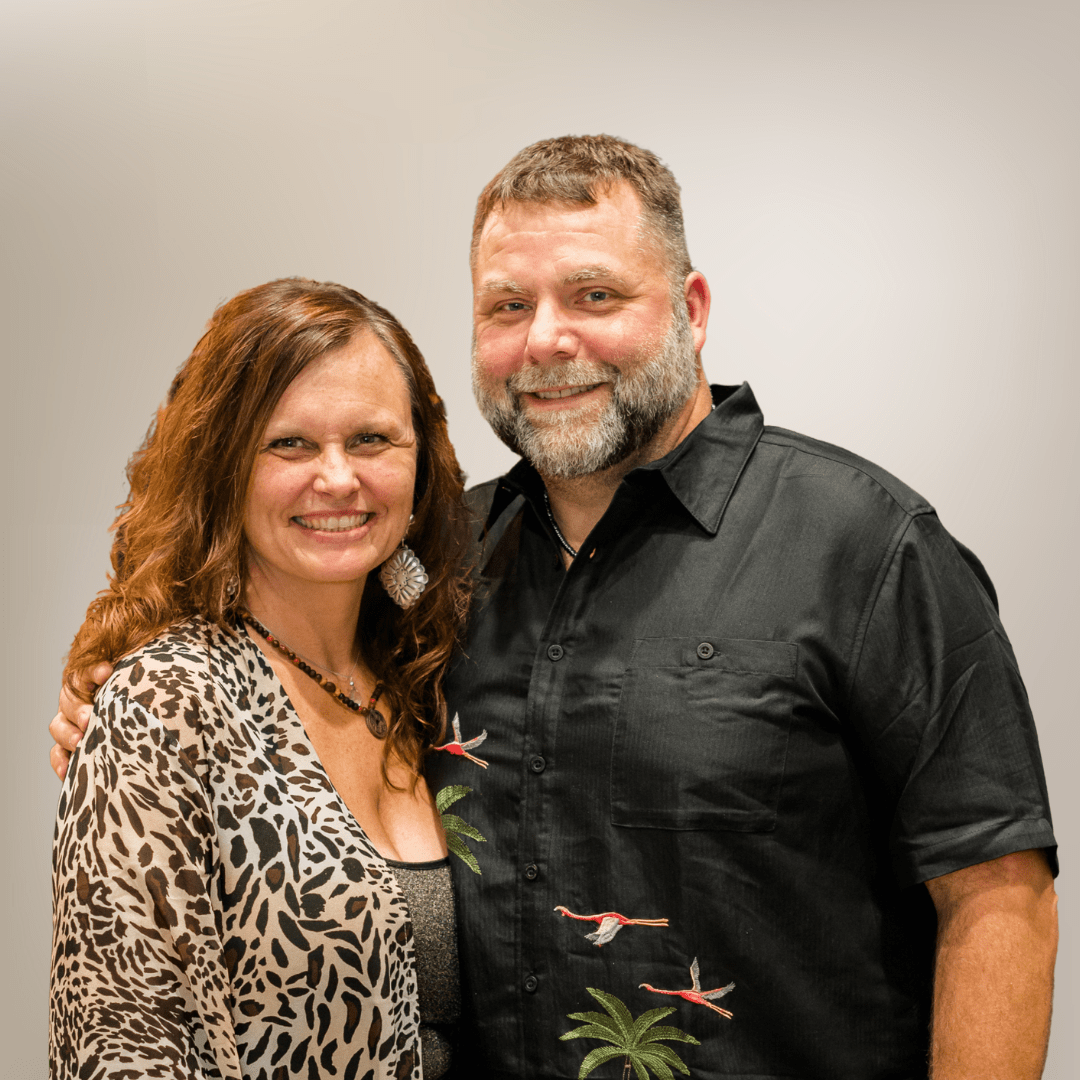 Smiling couple posing together in casual attire.
