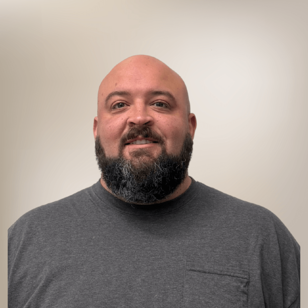 Bearded man smiling in gray shirt